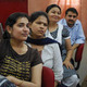Three women sit in a lecture